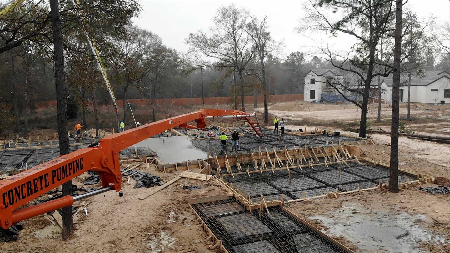 Concrete pump placing a foundation at a residential build site