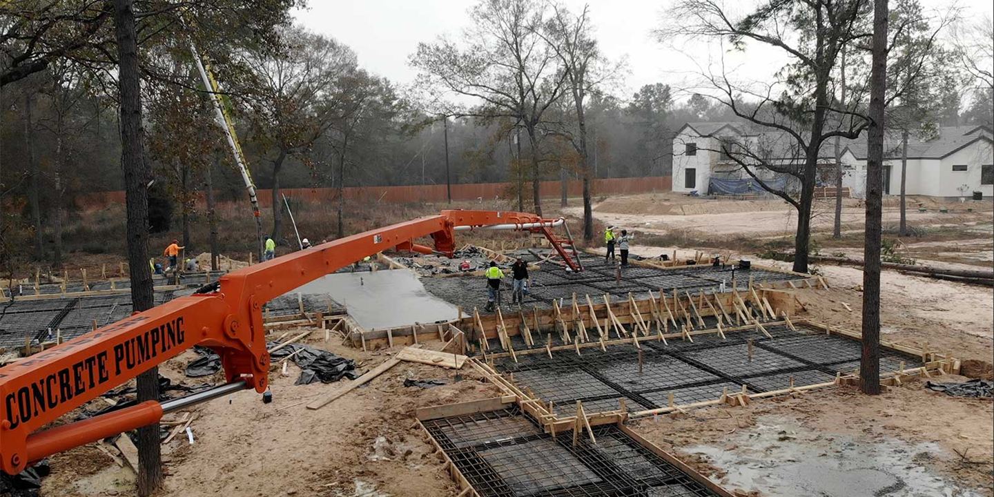 Concrete pump placing a foundation at a residential build site