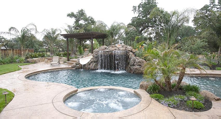 Custom slide curving into a backyard pool