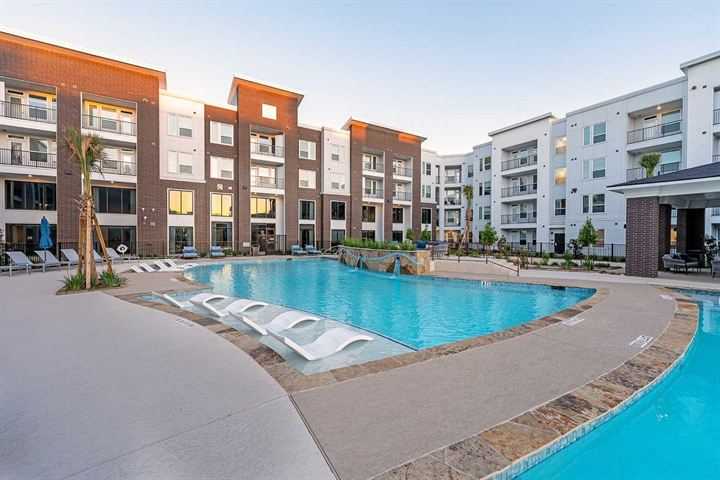 Resort-style apartment community pool with lounge chairs
