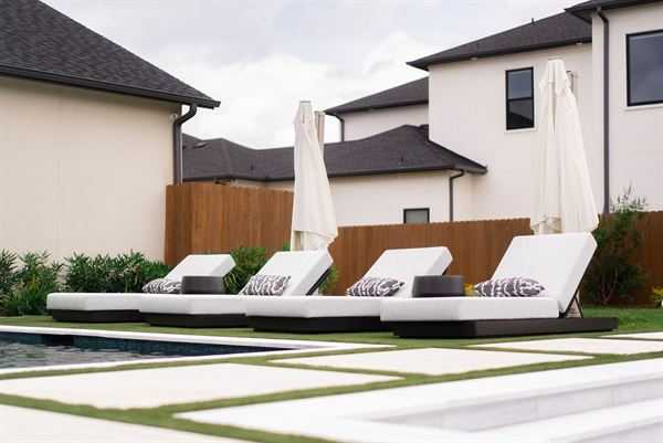 Custom deck with lounge chairs beside a modern home