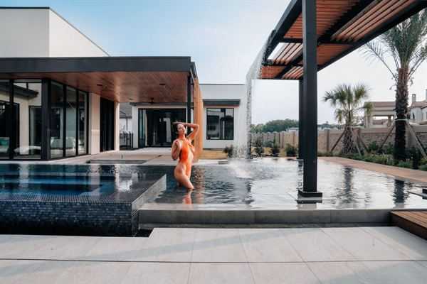 Outdoor living area with pergola, seating and pool lighting