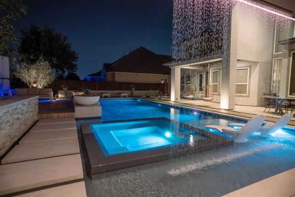 Pool with sculpted water features and stonework