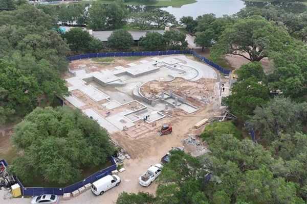 Aerial view of a water park under construction among mature trees