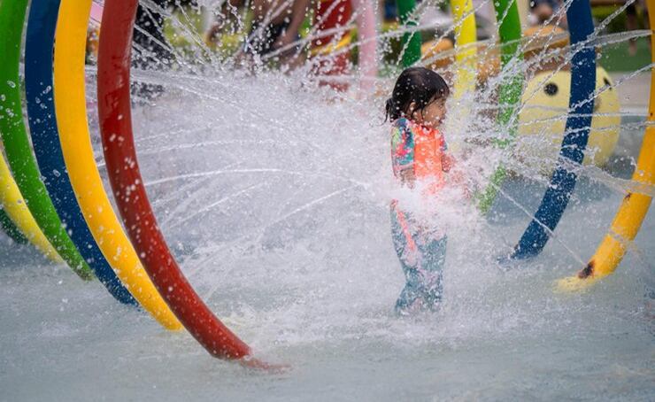 Colorful splash pad with sprayers and a dumping bucket